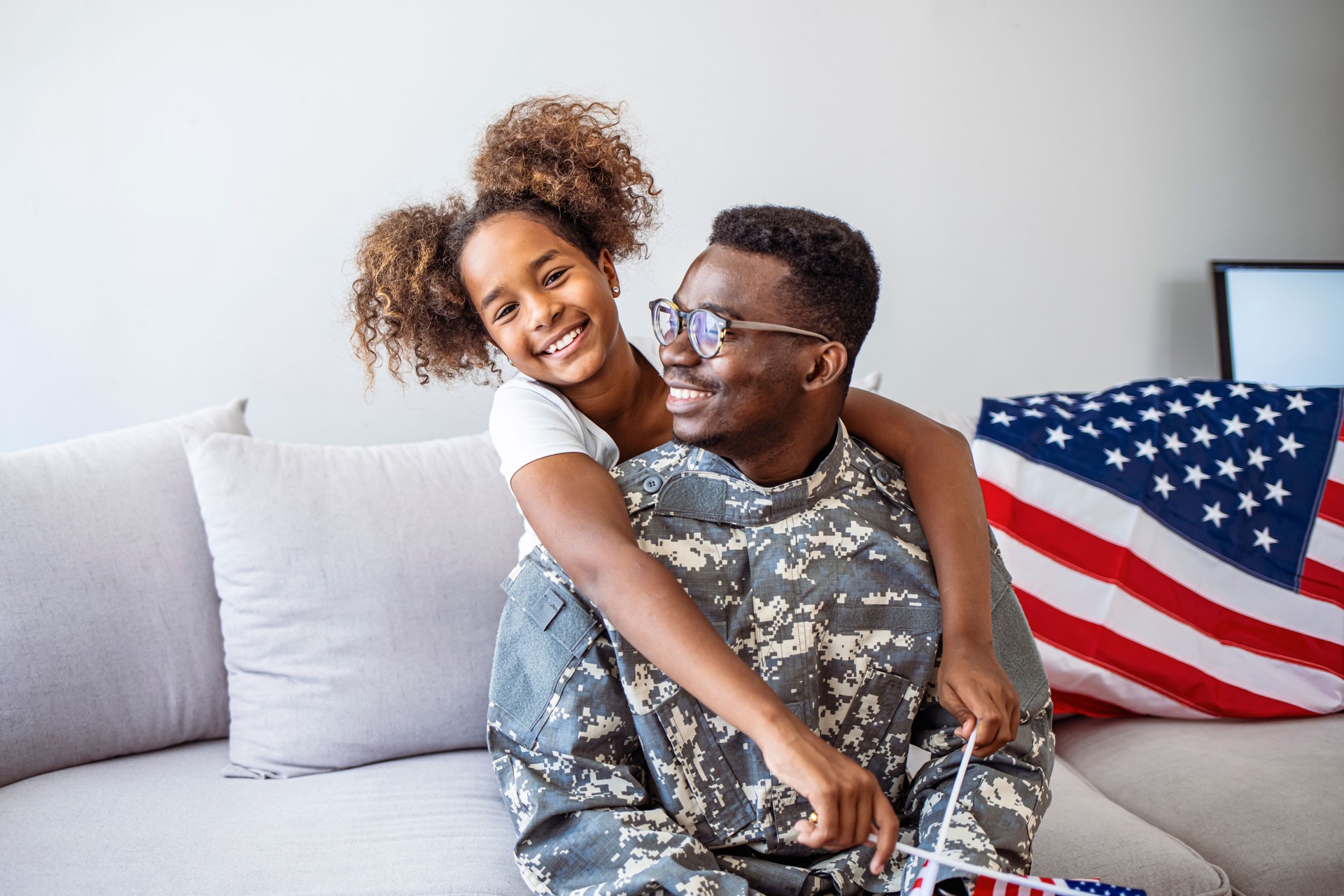Photo of American soldier playing with his daughter at home.